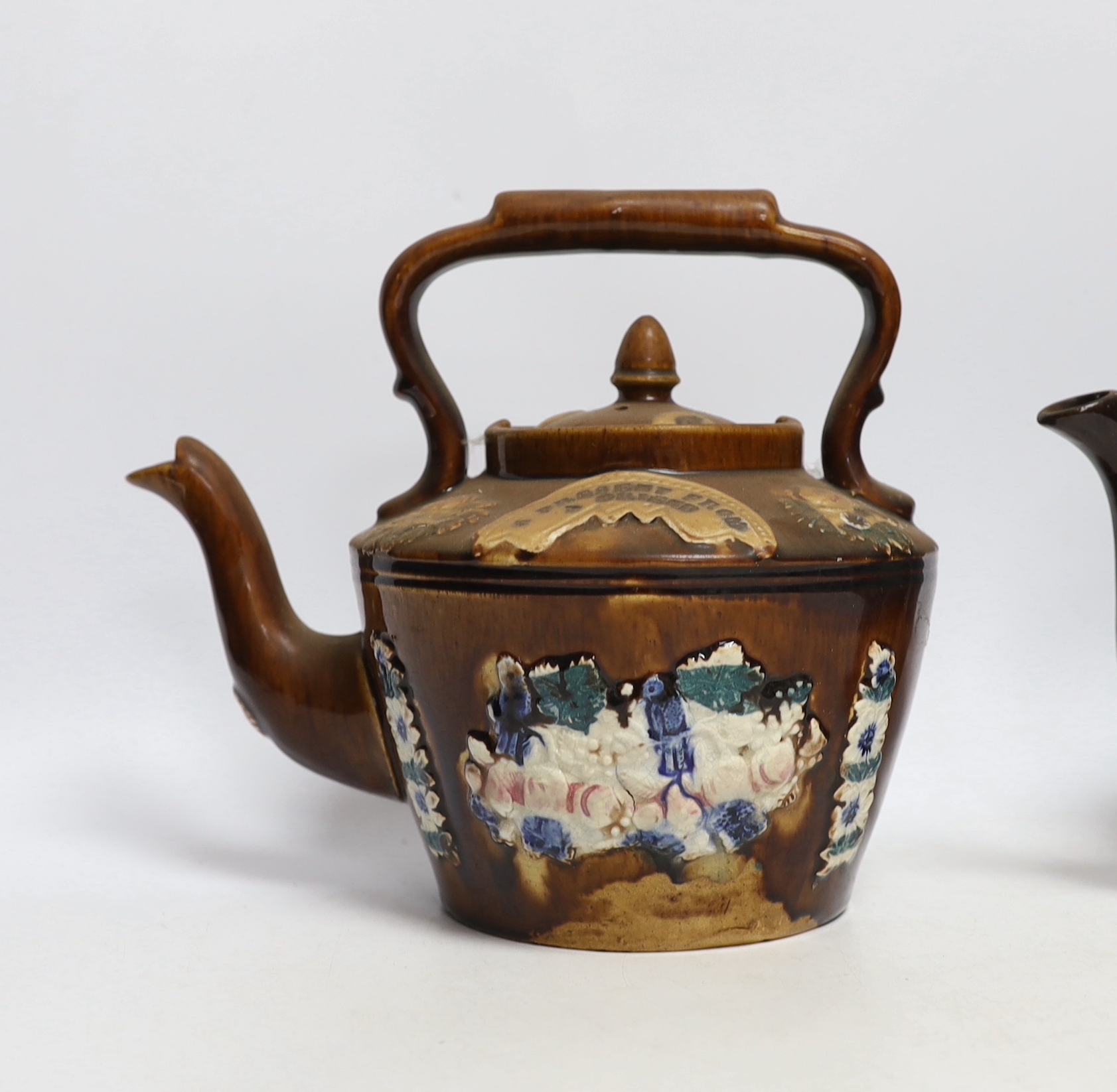 Two Measham Barge ware glazed pottery teapots, decorated in relief, largest 24cm wide